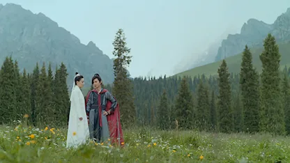 Cảnh phim Tân Tuyệt Đại Song Kiều – hai nhân vật đứng giữa đồng cỏ và núi non hùng vĩ, gợi chất võ hiệp cổ trang.