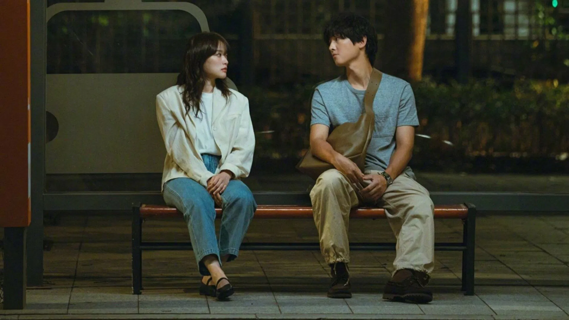Cảnh phim Thanh Xuân Của Tôi – My Youth: hai nhân vật chính ngồi cùng nhau tại trạm xe buýt trong đêm, không khí nhẹ nhàng và trầm lắng.